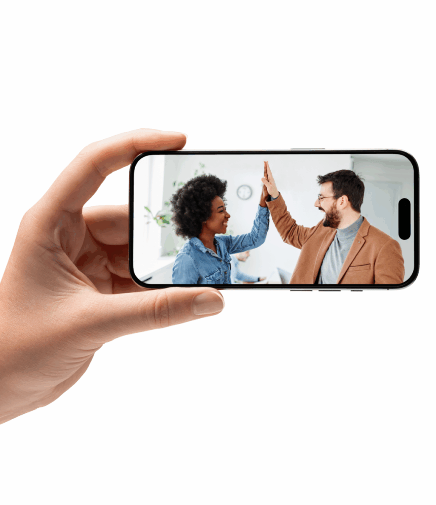 Digitalt samarbejde via smartphone – to kollegaer giver high-five efter vellykket IT-projekt og online supportløsning i Microsoft 365